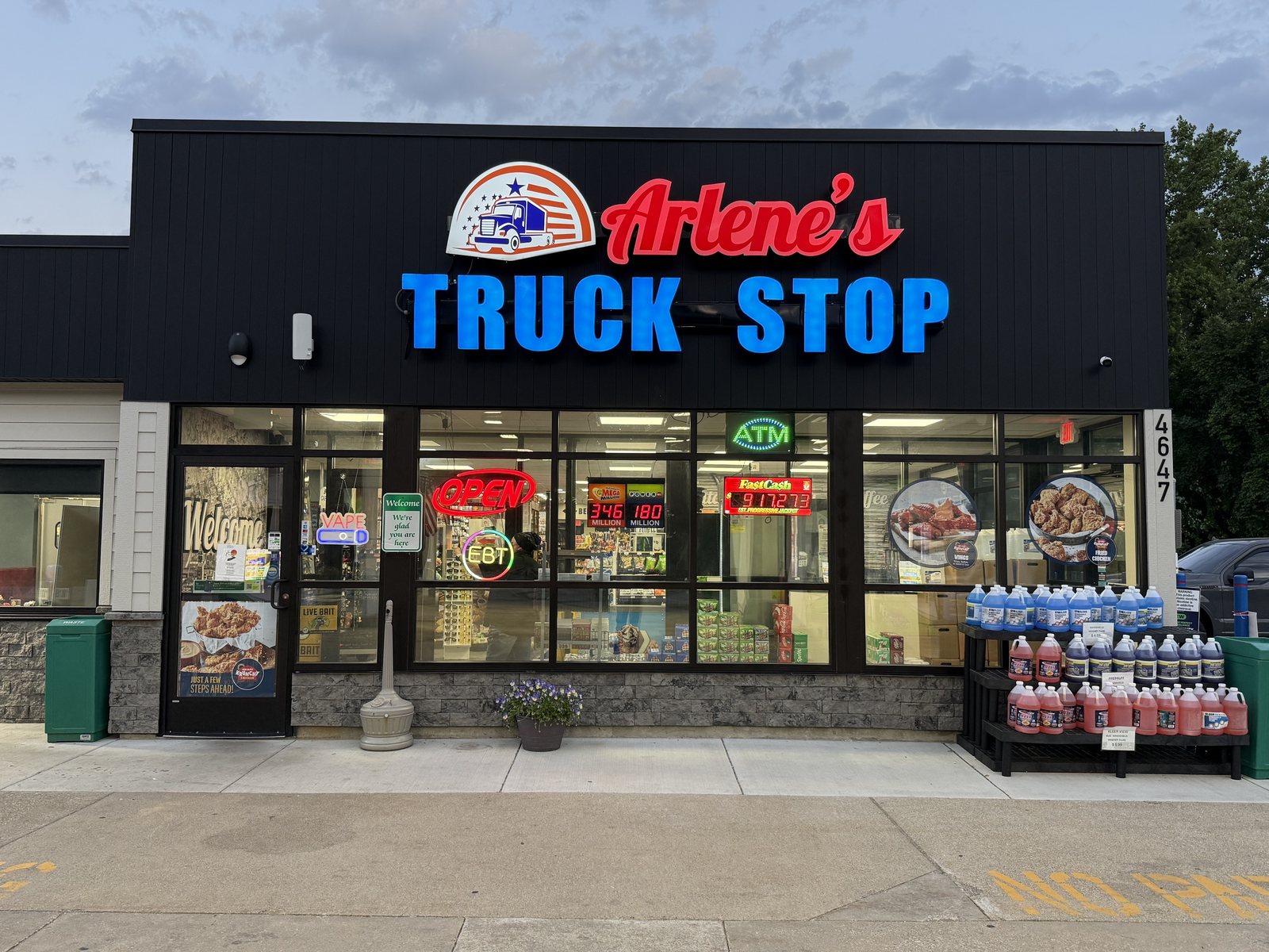 Front entrance of Arlene's Truck Stop with neon signs and remodeled storefront